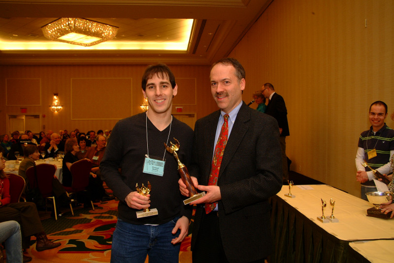 Howard Barkin receiving trophies from Will Shortz